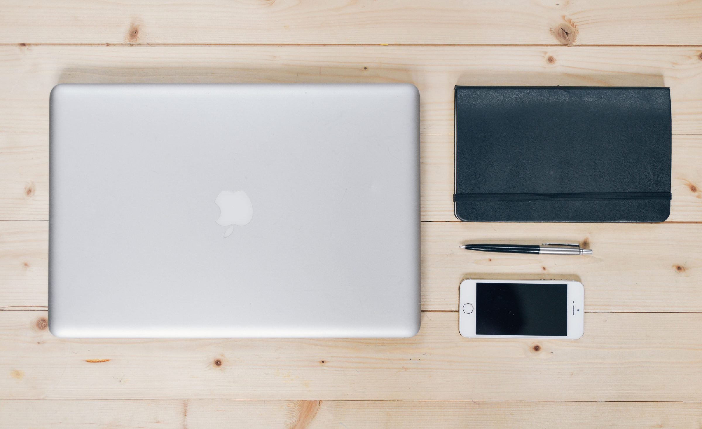 Laptop and everyday devices arranged on a working desk
