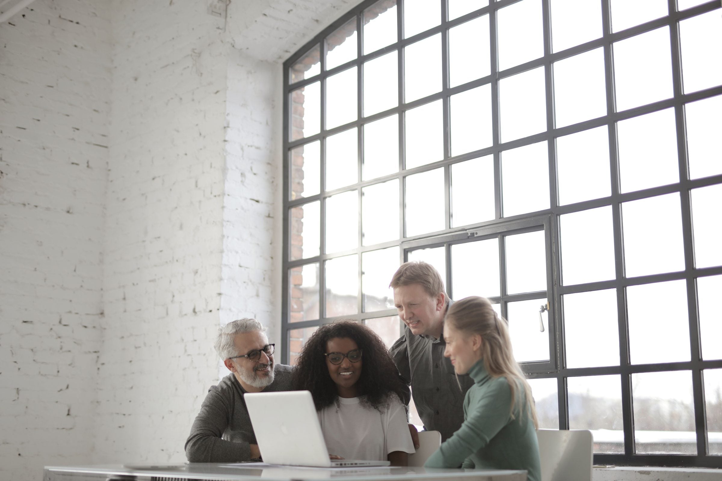 Colleagues working together around a laptop